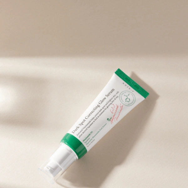AXIS-Y Glow Serum with natural ingredients and skincare props for brightening and dark spot care